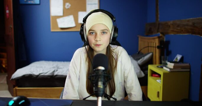 Shot of a young teenage gamer recording a video for her blog at home