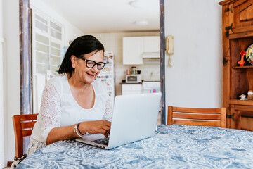 latin elderly woman working with computer at home in Mexico city