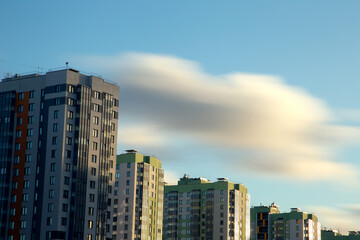 Fototapeta na wymiar Long exposure view of blurry clouds over the blue sky over high-rise buildings.City landscape. 