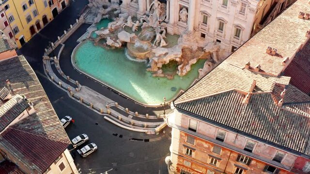 Aerial view of the Trevi Fountain or Fontana di Trevi, baroque landmark in the center city of Rome, Italy. Famous tourist attraction in Roma, Italia seen from drone flying in the sky