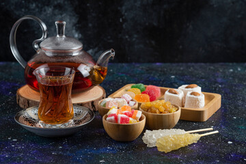 Fregrant tea with sweet candies on blue background