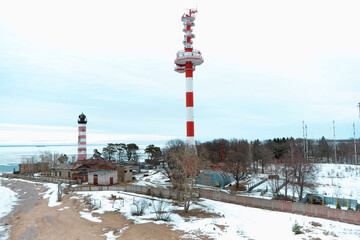 Fototapeta na wymiar white and red lighthouswhite and red lighthouse on the beach in wintere on the beach in winter