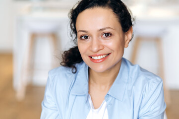 Fototapeta premium Close-up portrait of an attractive happy confident adult mixed race brunette woman, business lady dressed in stylish clothes, looking at the camera, cute smiling
