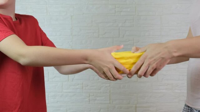 People, mother and som are fighting for a yellow pack, they take away each other parcell, delivery