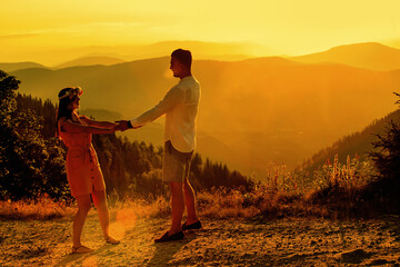 Beautiful couple walking on the mountain during sunset.