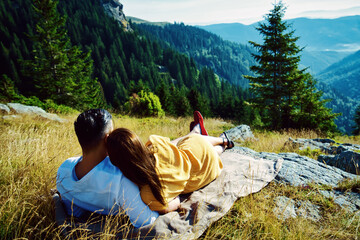 Happy couple hugging on the top of a mountain.