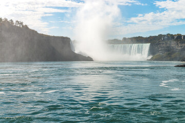 View at the Horseshoe Falls and tall cloud above it from Niagara river