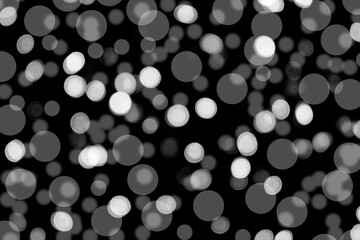 Abstract background of white bokeh on black background With some blur