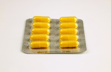 yellow pills in a blister on a white background 