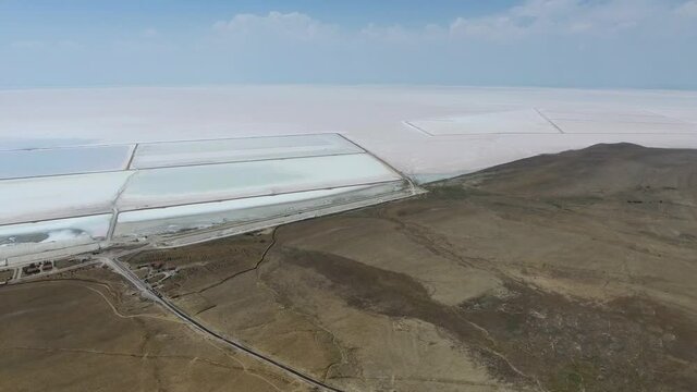 Salt production facilities and saline evaporation pond fields in the white salty lake.Halophile organisms impart a red colour.Halite salts sodium chloride NaCl mineral salinity lakewater salting ponds