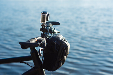 Action Camera on a bike with a bikepacking bag in a waterproof case against the backdrop of river.