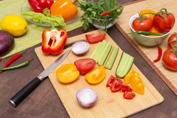 Various vegetables for cooking healthy vegetarian vegan diet food. Cutting vegetables on wooden board on kitchen