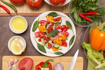 Different vegetables and fresh mixed vegetable salad with spinach leaves in white plate. Diet, vegan, vegetarian, healthy food concept