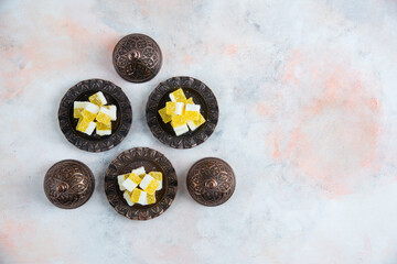 Yellow candies on crockery over white background