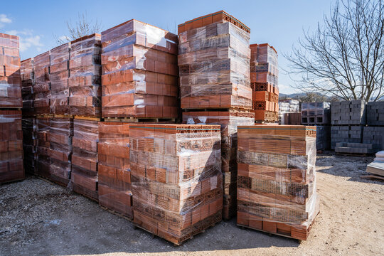 Stacked bricks and blocks building material at warehouse or construction site in sunny day