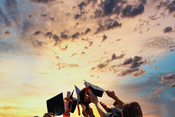 International students in mortar boards and bachelor gowns with diplomas.