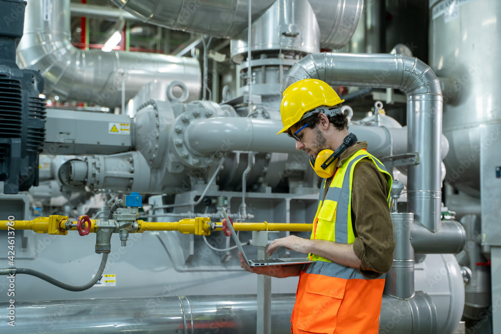 Aufkleber engineer using laptop computer working in thermal power plant at industry factory.