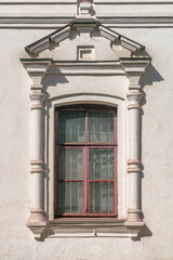 Large window in the facade of the building in the classical Baroque style on a sunny day.