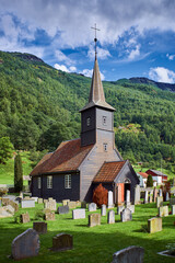 Fototapeta na wymiar Graveyard and wooden old church in the mountains