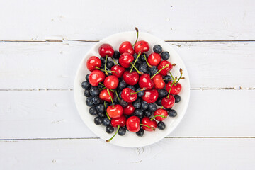 Fresh organic fruit cherry and blueberry on wooden background