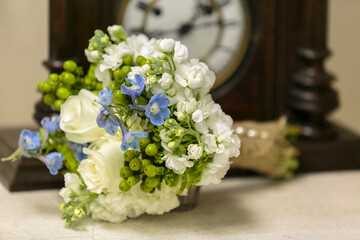 White roses and Periwinkle wedding bouquet set on a table