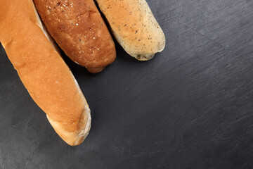 Freshly baked bread loaf bun roll round long mix verity copy text space border frame black background