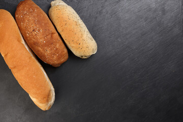 Freshly baked bread loaf bun roll round long mix verity copy text space border frame black background