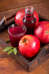 Glass of pomegranate juice on a wooden background.