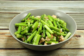 Traditional fried and stirred cutting fresh asparagus with chopped peeled shrimp serving on the plate. Famous appetizer salad menu in Asia restaurant.  
