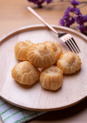 Eclairs on wood plate on a wodden background. Eclairs with cream.