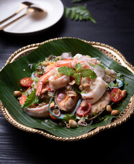 Spicy sea food (boiled shrimp ,mussels and squid) is mixed with fresh vegetable and spicy sauce, Thai food style.