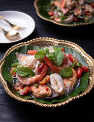 Spicy sea food (boiled shrimp ,mussels and squid) is mixed with fresh vegetable and spicy sauce, Thai food style.