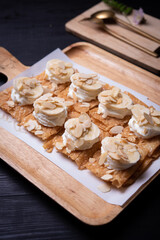 Roti desserts with whipped cream and nut on wood