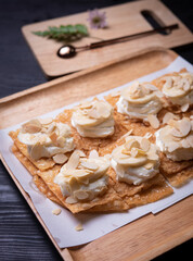 Roti desserts with whipped cream and nut on wood