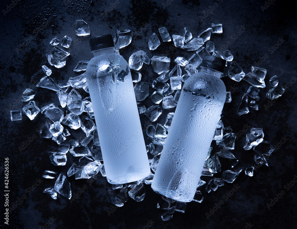 Poster Water bottle is cooling on the ice cube,wood background