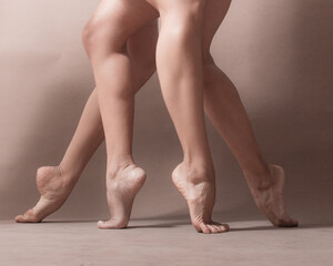 Legs of two Latin women dancers artists standing on tiptoe with their bare feet