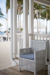 Beach house white blue cane chair patio porch hamptons relax holiday travel tropical palm trees