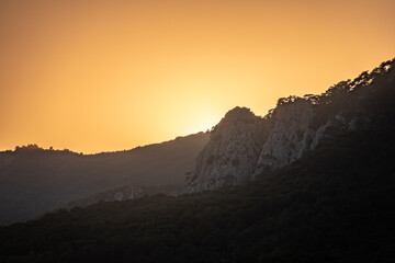 Fototapeta premium Sunset in the mountains among the green trees