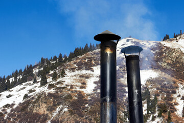 metal rooftop chimney of a diner against the backdrop of mountains and sky