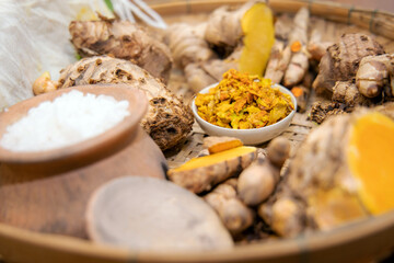 Herbs in bamboo basket  ingredients for override the salt pot hot compress, Thai traditional medicine hot compress therapy. Thai herbal for health massage such as Phlai, Turmeric and other.