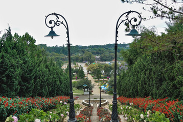 A stone staircase descends from the hill. There are decorative lamps on the sides. Nearby there are...