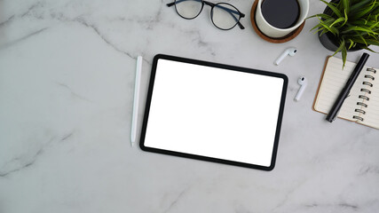 Top view of modern workplace with digital tablet, stylus pen, notebook, coffee cup and wireless...