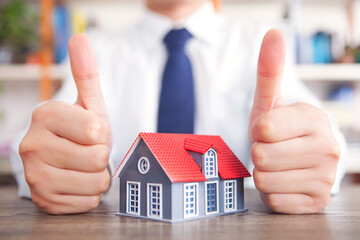 Thumbs up beside the model house