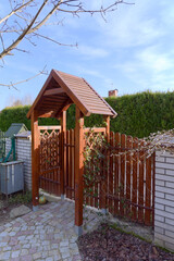 Wooden gate and garden fence and a path from paving stones 