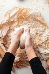 Kneading dough for pizza cooking on the parchment paper