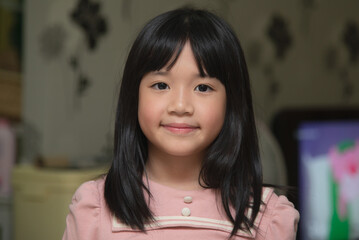 Cute Asian girl smiling and looking at camera