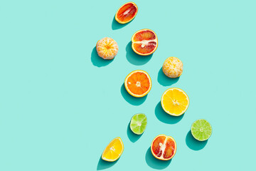 Colorful fruit pattern from fresh citrus, lemon, red orange, tangerine and lime on blue background. Summer food.