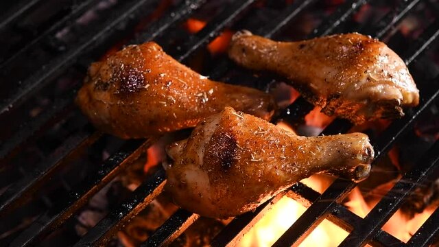 Grilled chicken leg on the flaming grill