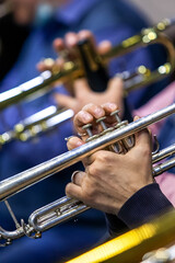 Hands of a musician playing the trumpet in the orchestra close up