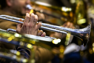 Hands of a musician playing the trumpet in the orchestra close up 